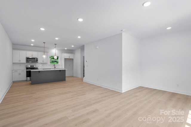 190 Cherry Springs Ln Unit 1-E, Asheville, NC 28804 - kitchen with stainless steel appliances, white cabinets, open floor plan, light wood finished floors, and recessed lighting
