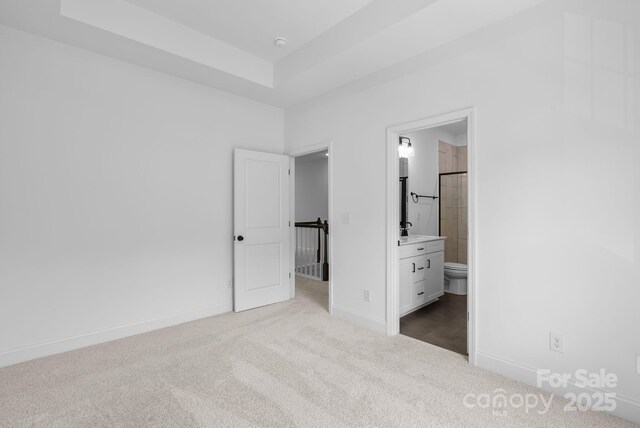190 Cherry Springs Ln Unit 1-E, Asheville, NC 28804 - unfurnished bedroom featuring carpet flooring, baseboards, a raised ceiling, and ensuite bath