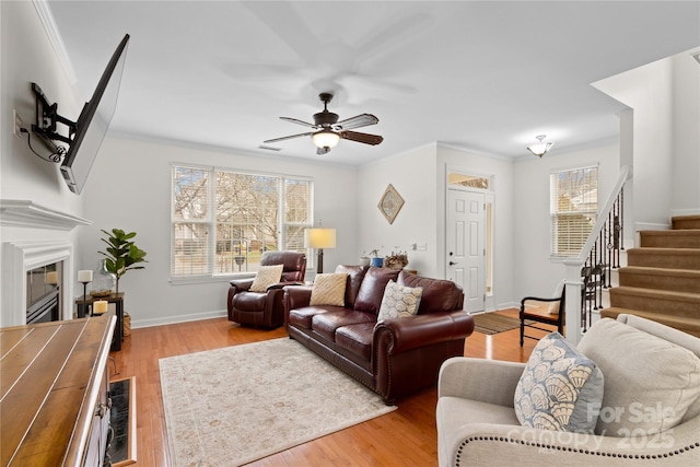 living room featuring ornamental molding, a wealth of natural light, and light wood-type flooring