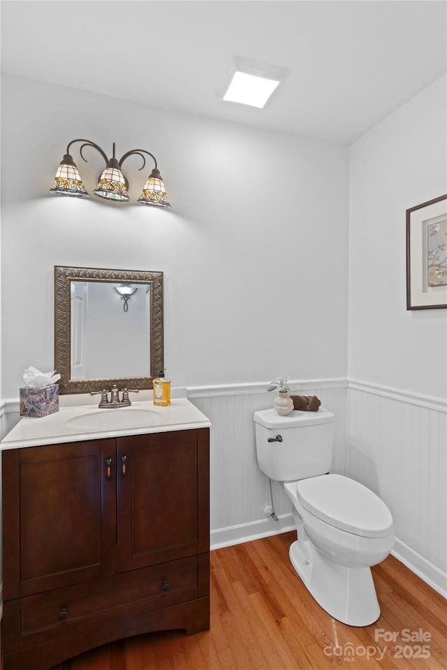 bathroom with hardwood / wood-style flooring, vanity, and toilet