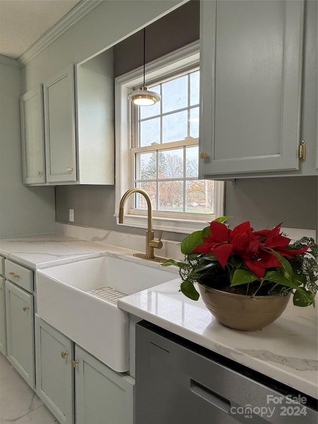 kitchen featuring light stone counters, ornamental molding, sink, and hanging light fixtures