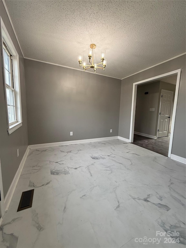 spare room with ornamental molding, a textured ceiling, and a notable chandelier