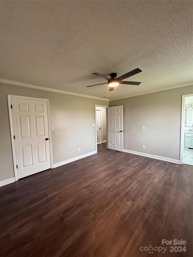 unfurnished bedroom with ensuite bath, a textured ceiling, ceiling fan, crown molding, and dark hardwood / wood-style floors