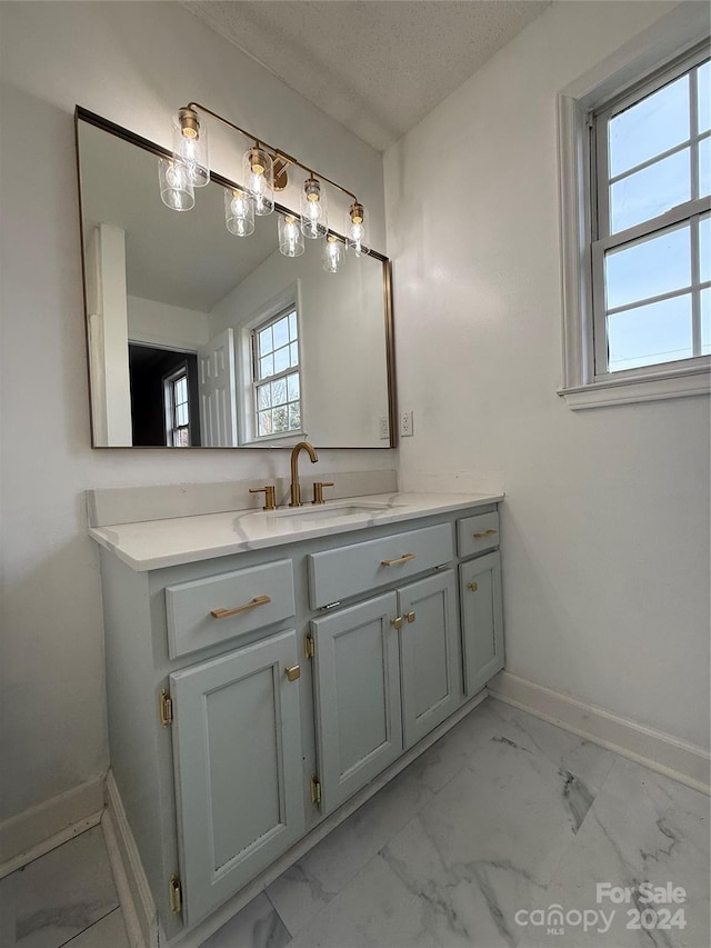 bathroom featuring vanity, a healthy amount of sunlight, and a textured ceiling