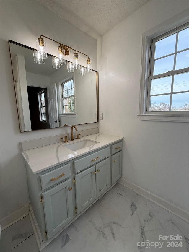 bathroom featuring plenty of natural light, vanity, and a textured ceiling