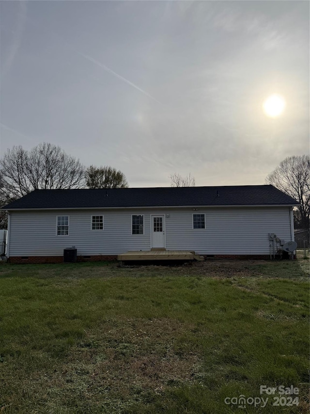 rear view of house featuring central AC, a yard, and a deck