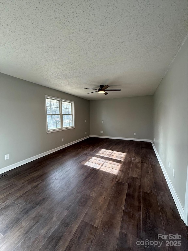 unfurnished room with ceiling fan, dark hardwood / wood-style flooring, and a textured ceiling