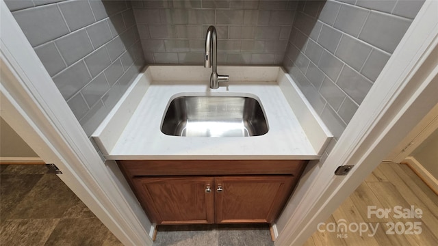 room details with light countertops, decorative backsplash, a sink, and brown cabinets