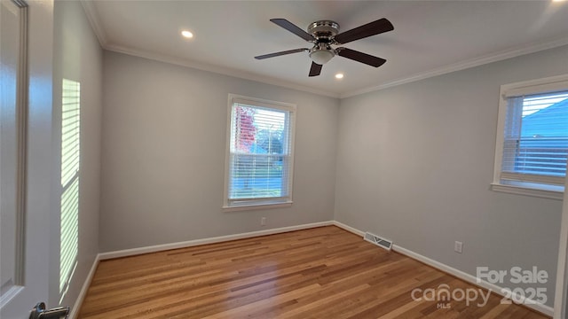 spare room featuring baseboards, visible vents, ornamental molding, wood finished floors, and recessed lighting