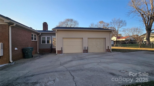 garage featuring driveway and fence