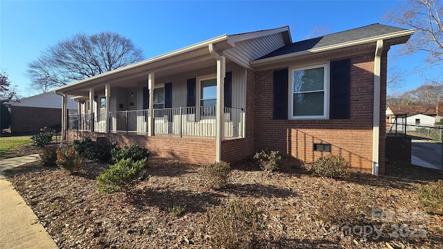 view of front facade featuring crawl space, covered porch, and brick siding