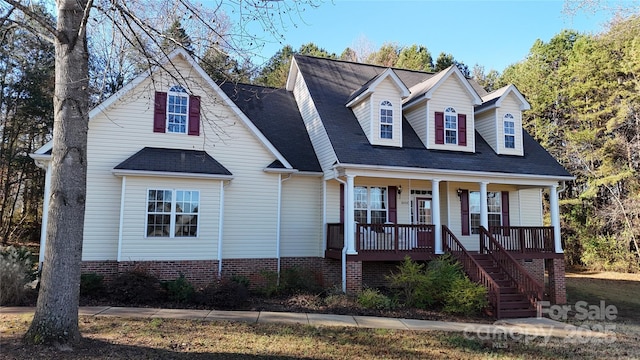 cape cod-style house with stairway and a porch