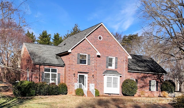 view of front of home with a front lawn, brick siding, and a shingled roof