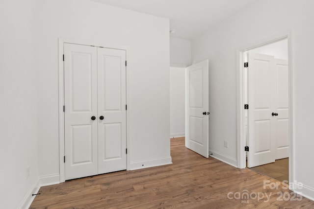 unfurnished bedroom with wood-type flooring and a closet