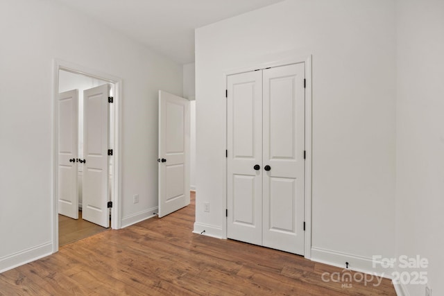 unfurnished bedroom featuring hardwood / wood-style flooring and a closet