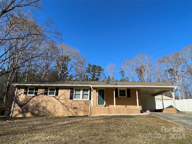 ranch-style house with a front lawn, a porch, and a carport