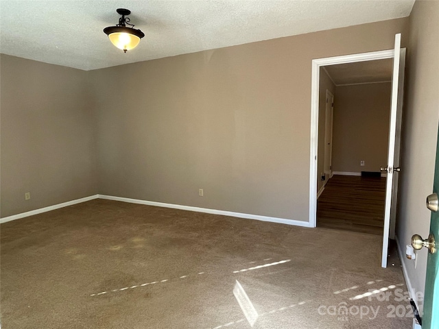 carpeted empty room with a textured ceiling