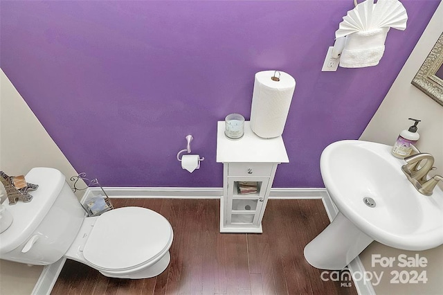 bathroom with wood-type flooring, toilet, and sink