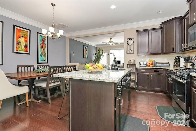 kitchen with dark brown cabinets, dark hardwood / wood-style flooring, an island with sink, and appliances with stainless steel finishes