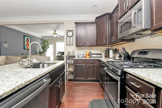 kitchen with tasteful backsplash, stainless steel appliances, ceiling fan, dark wood-type flooring, and sink