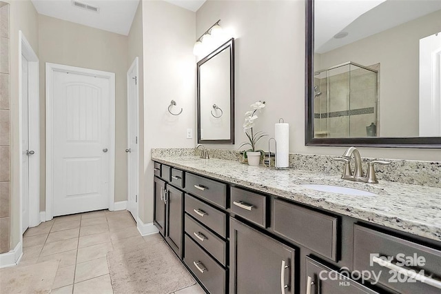 bathroom featuring tile patterned flooring, vanity, and a shower with shower door