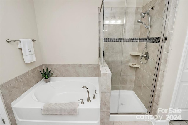 bathroom featuring shower with separate bathtub