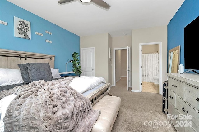 carpeted bedroom with ensuite bathroom and ceiling fan