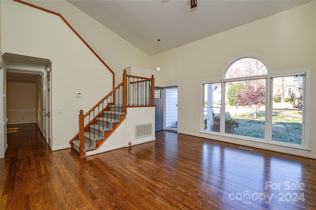 unfurnished living room featuring dark hardwood / wood-style floors and high vaulted ceiling