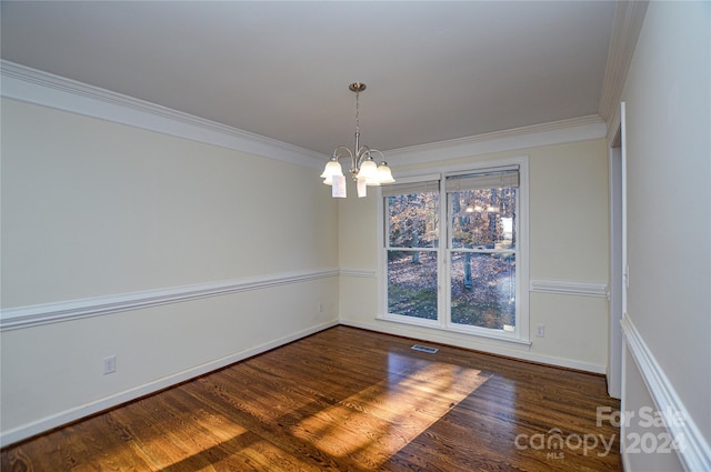 empty room with a notable chandelier, dark hardwood / wood-style flooring, and crown molding