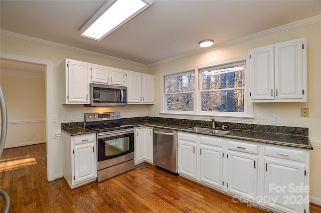 kitchen featuring sink, dark wood-type flooring, stainless steel appliances, white cabinets, and ornamental molding