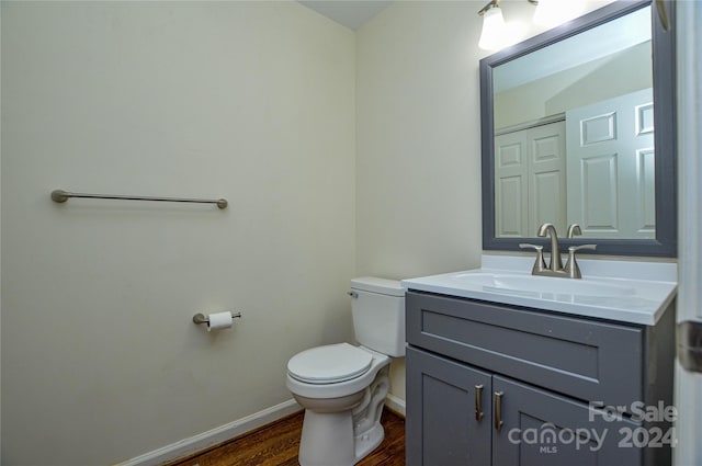 bathroom featuring hardwood / wood-style floors, vanity, and toilet