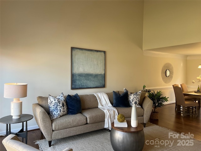 living room featuring a high ceiling, crown molding, and hardwood / wood-style floors