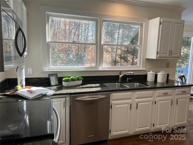 kitchen featuring white cabinetry, appliances with stainless steel finishes, sink, and dark stone counters