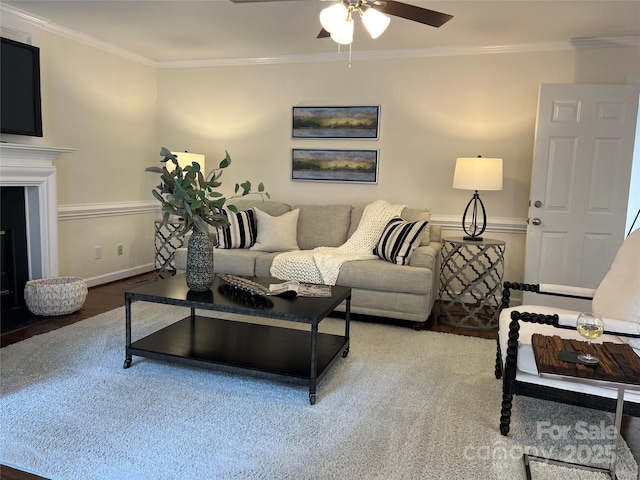 living room featuring ceiling fan, ornamental molding, and hardwood / wood-style floors