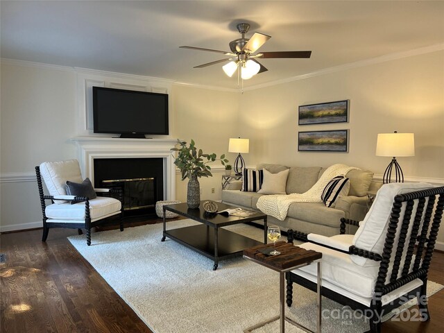 living room with crown molding, ceiling fan, and dark hardwood / wood-style floors