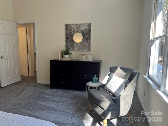 sitting room featuring a healthy amount of sunlight and dark colored carpet