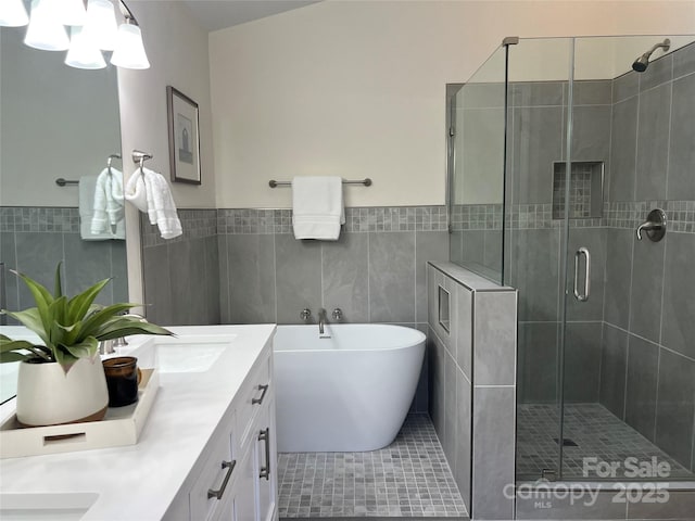 bathroom featuring tile patterned flooring, vanity, independent shower and bath, and tile walls