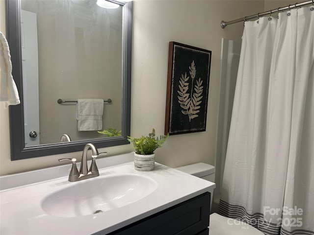 bathroom featuring vanity, toilet, and curtained shower