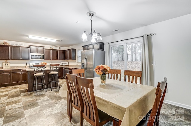 dining space featuring sink and an inviting chandelier