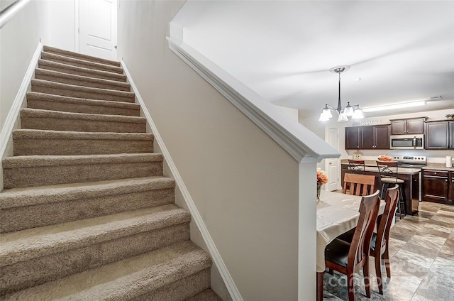 staircase featuring an inviting chandelier