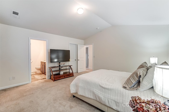 carpeted bedroom featuring ensuite bathroom and vaulted ceiling