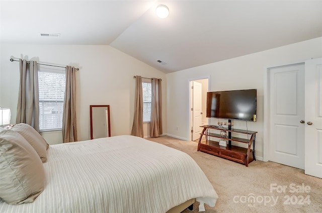 carpeted bedroom with vaulted ceiling and multiple windows