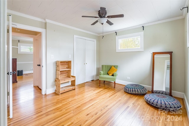 living area with ceiling fan, plenty of natural light, light hardwood / wood-style floors, and ornamental molding