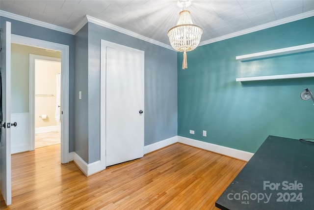 interior space featuring light wood-type flooring, crown molding, and an inviting chandelier