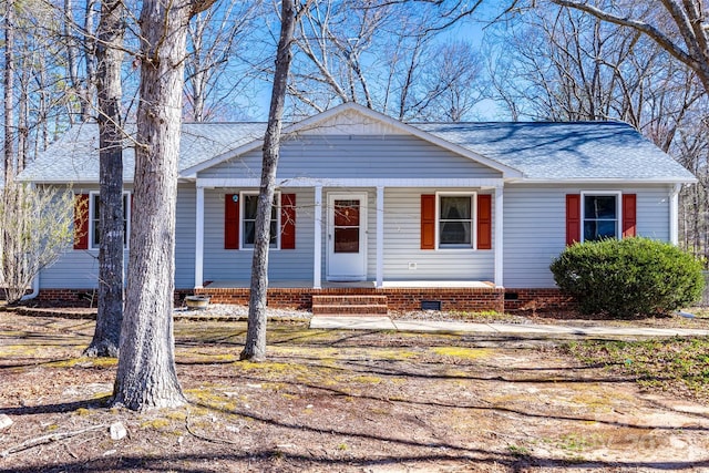 ranch-style house featuring crawl space, covered porch, and roof with shingles