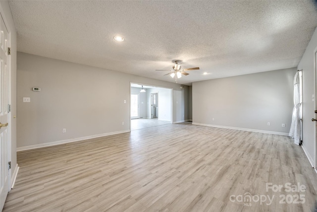 unfurnished room featuring a ceiling fan, baseboards, plenty of natural light, and light wood finished floors