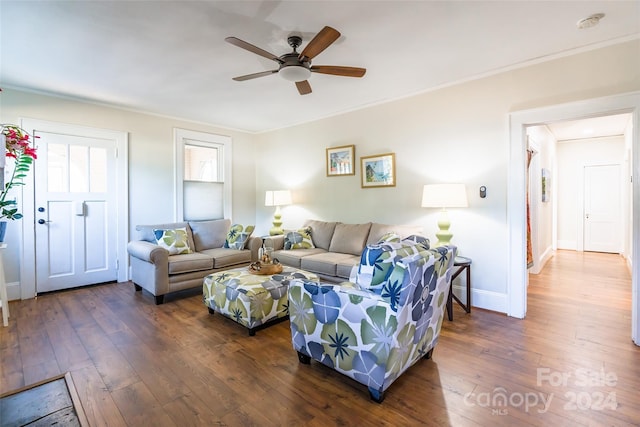 living room featuring dark hardwood / wood-style floors, ceiling fan, and crown molding