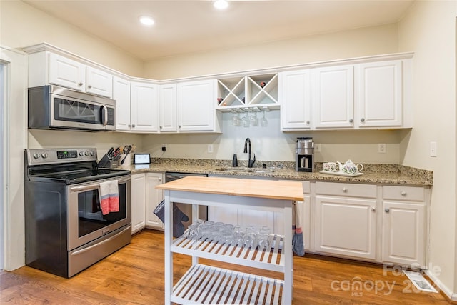 kitchen featuring white cabinets, light hardwood / wood-style floors, sink, and stainless steel appliances