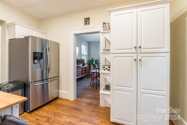 kitchen featuring wooden counters, white cabinets, light hardwood / wood-style floors, and stainless steel refrigerator with ice dispenser