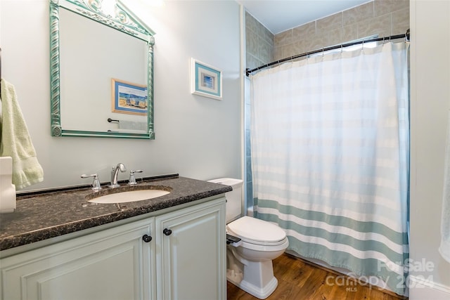 bathroom with a shower with shower curtain, vanity, hardwood / wood-style flooring, and toilet